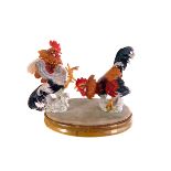 A Staffordshire white glazed bird figure, together with two porcelain fighting cocks on stand and