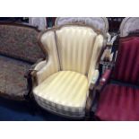 A French Empire style gilt wood wing back armchair, in yellow striped fabric on fluted tapering