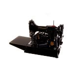 A portable cased electric Singer sewing machine, together with a selection of thread and other