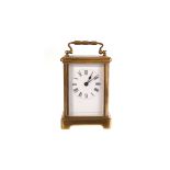 A brass and glazed carriage clock, having black Roman numerals on white enamel face, with key