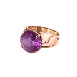 A gold and synthetic colour change alexandrite dress ring, the large round cut stone set in claw