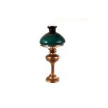 A Victorian oil table lamp, with brass effect base, green and opaque shade and clear glass funnel