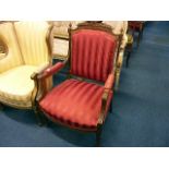 A French walnut Second Empire Period armchair, upholstered in red striped fabric, with triumphal