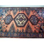 A red ground handmade Persian Heriz carpet, with multi-medallion central design, having geometric