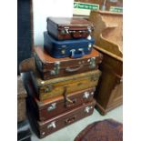 A group of vintage brown suitcases, including an army example