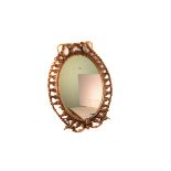 A once gilt painted oval wall mirror, the gilt paint faded to the decorative pierced design frame,