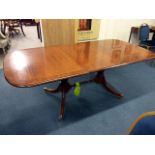 A reproduction sabre leg mahogany extending dining table, having burr walnut edge, on brass casters,