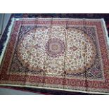 A beige ground Keshan carpet, with central red medallion, surrounded by beige and red floral