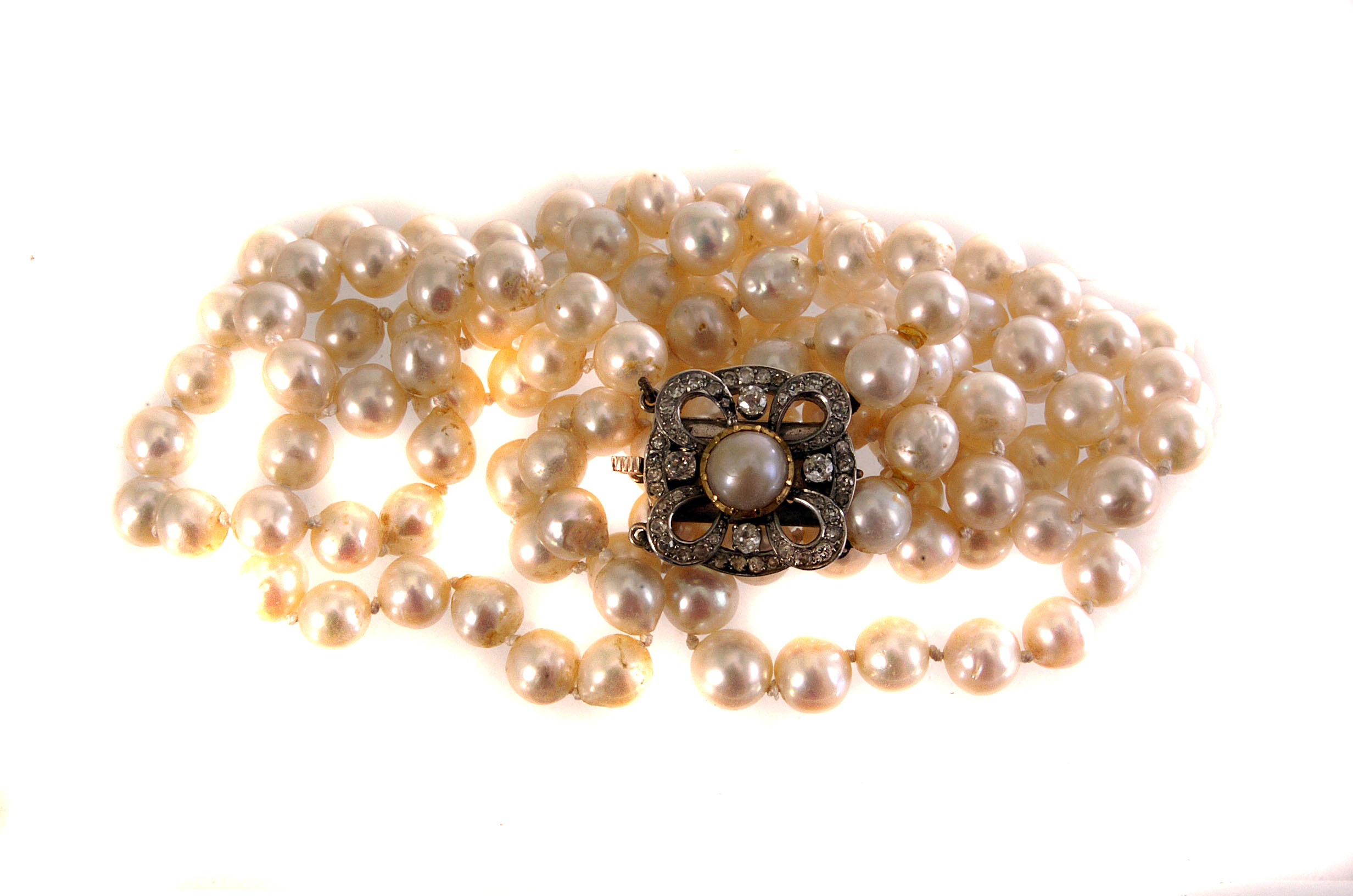 A fine double strand freshwater pearl necklace, the uniform white pearls on white cotton, united