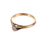 An 18ct gold illusion set solitaire ring, the small round cut stone set in white metal on an 18ct