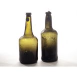 An early 18th century olive green glass cylinder bottle, together with a later green glass mallet