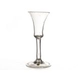 An 18th century wine glass, with slender bell shaped bowl on a multi cotton twist stem, and plain