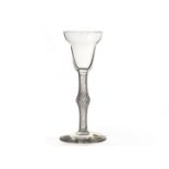 An 18th century cordial glass, c.1750 with bell shaped bowl on a knopped air twist stem on plain