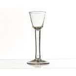 An 18th century cordial glass, with pail shaped bowl on a plain stem, and foot 15cm H