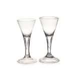 A pair of 18th century wine glasses of drawn conical form with tear drop captive bubble stem, on