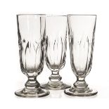 A set of three 19th century champagne glasses, of moulded form with gathered decoration to the