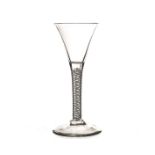 An 18th century wine glass, with drawn trumpet bowl on a cotton twist stem, on a plain foot 17cm H