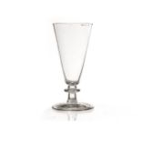 A late 18th century dwarf ale glass, with conical bowl over a short knopped stem, on a plain,