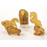 Two pairs of modern carved amber animals, one pair modelled as horses, the other pair as dogs,