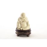 A 19th century Chinese carved figure of Buddha, the seated laughing figure in robe wearing bead