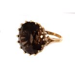 A 9ct gold and Smokey quartz dress ring, the large round cut stone set in multi-claw mount, on 9ct