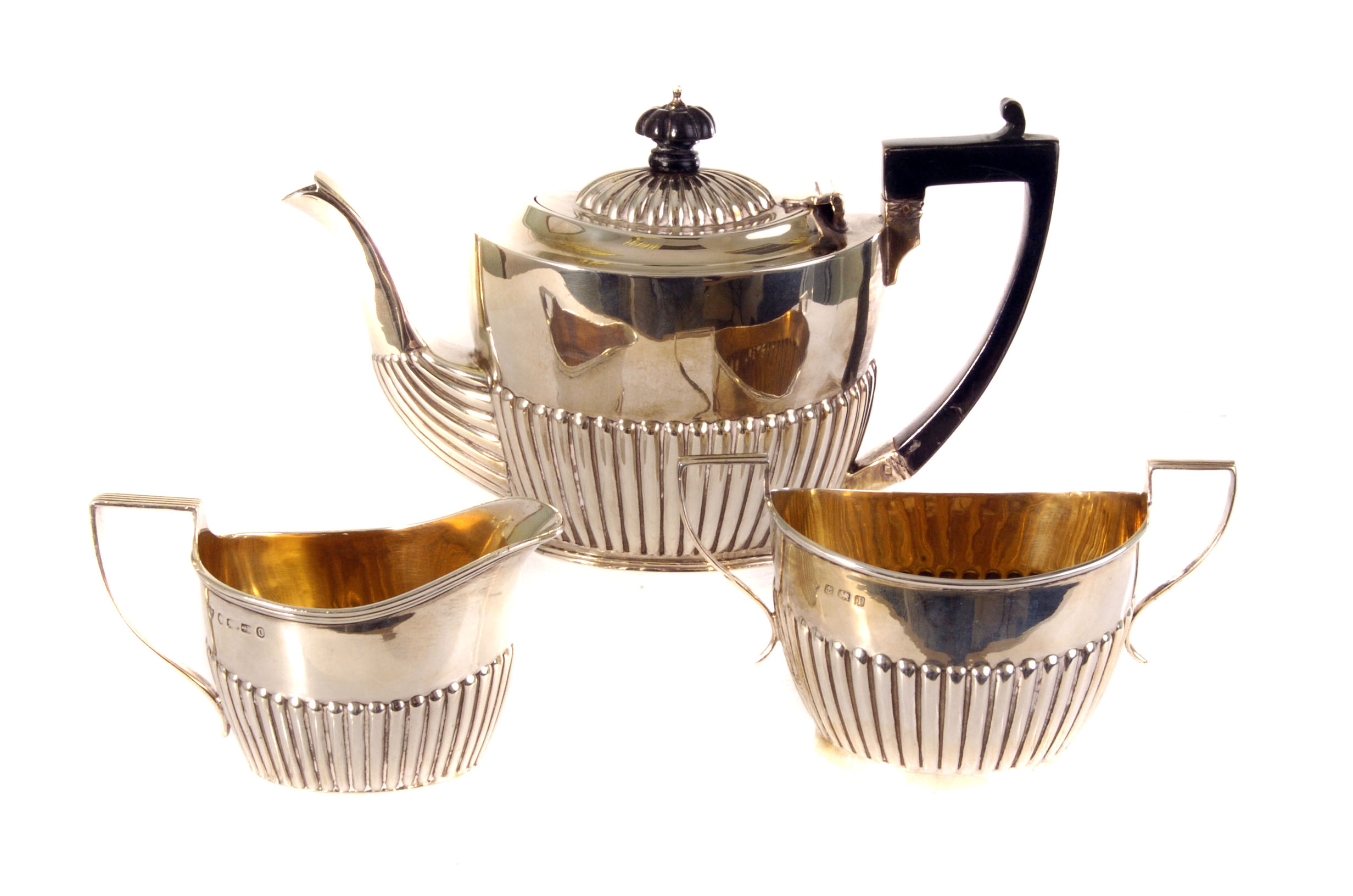 A matched silver three piece bachelors tea set, comprising a Victorian teapot marked Chester 1898,