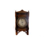 An aneroid carved oak wall barometer, having decorative floral and architectural design, with