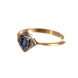 An Art Deco gem set engagement ring, the platinum square tablet centred with a blue stone, with four
