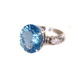 A 9K white gold and topaz dress ring, the large oval mixed cut stone set in four claw mount,