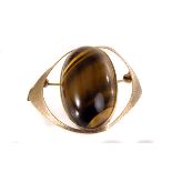 A 9ct gold and tigers eye brooch/pendant, the large oval stone with diagonal stripes in 9ct gold