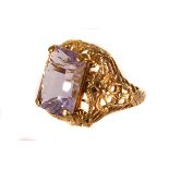 A 9ct gold and amethyst dress ring, the large mixed step cut stone in four claw mount, with