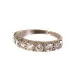 An 18ct white gold diamond half eternity ring, the seven brilliant cut stones in cut down claw