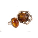 A silver and oval cabochon cut amber ring, size M, together with a large imitation amber and 800