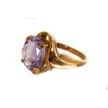 A 9ct gold, amethyst and topaz dress ring, the large oval cut amethyst in claw mount, diagonally