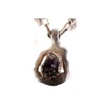 A modern Swedish silver and amethyst pendant by Jacob Hull, the abstract shaped mount with natural