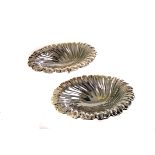 A pair of silver butter dishes, dated London 1895, by Carrington & Co, each having swirl design,