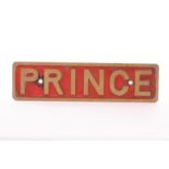 A cast brass nameplate ‘Prince’: the name appearing in raised brass letters against a weathered