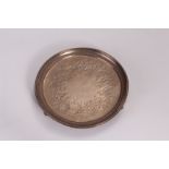 A George III silver card tray, circular on three curved supported having engraved floral design to