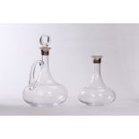 Two silver and glass decanters from Cartier, one with applied glass handle and with loop stopper,