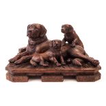 A large and fine Black Forest carved wooden dog group, modelled as a proud recumbent labrador mother