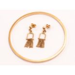 An 18ct gold bangle and pair of earrings, the plain bangle bearing strike mark to rim, and the