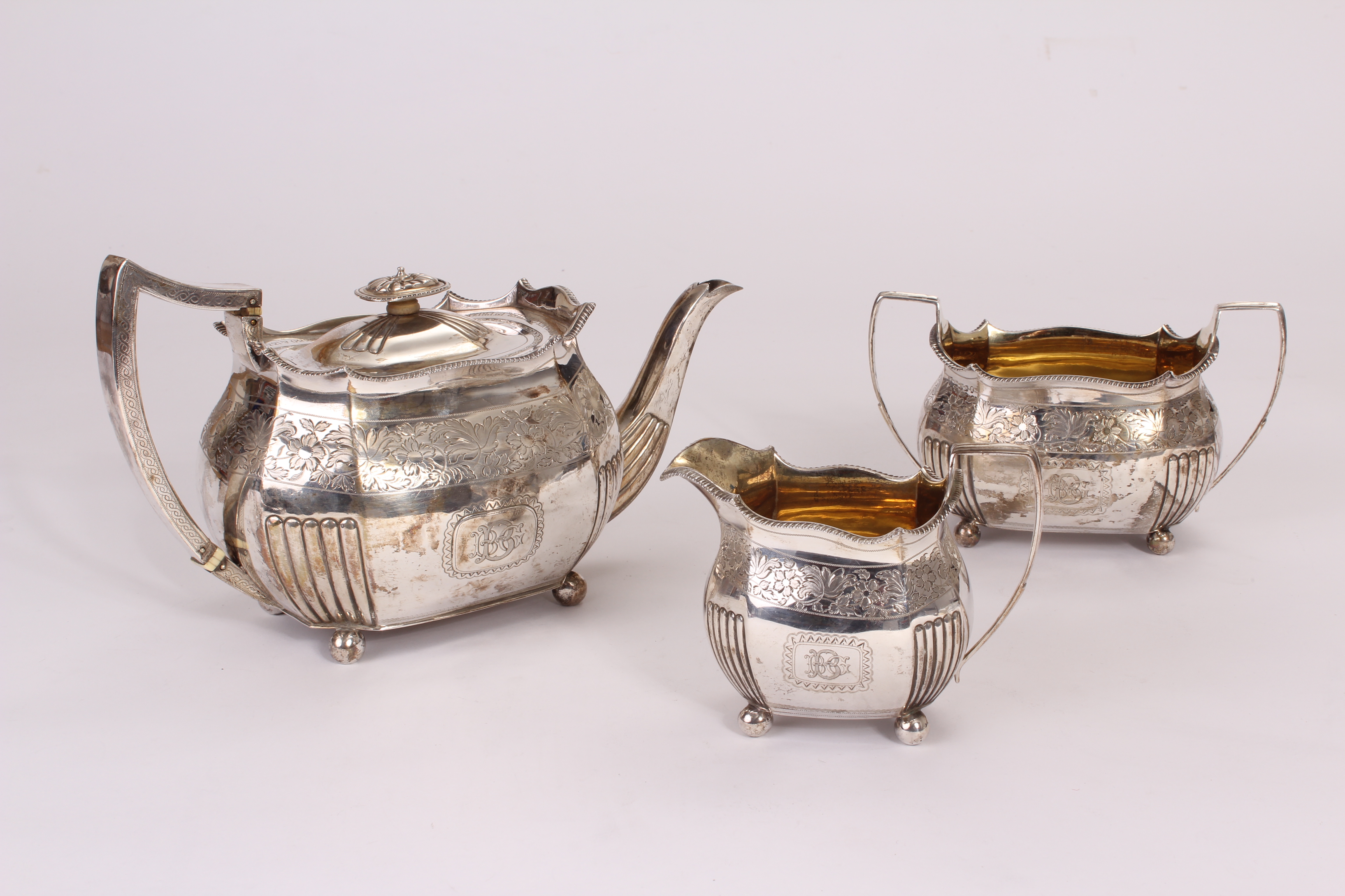 A George III silver three piece tea set possibly by John Wren, having flared gadrooned rims and part