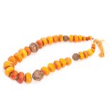 A large vintage amber bead necklace, having graduating caramel and toffee coloured pieces of amber