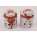 A pair of porcelain cylinder vase and covers, decortated in iron red neo-classical motifs, in the