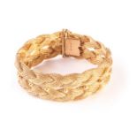 An 18ct gold bracelet, having two heavy plaited bands with beads to centre, marked to clasp,