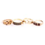 A group of four 9ct gold and yellow metal dress rings, one 1970s example with garnets, one crossover
