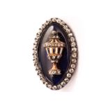 An eighteenth century enamel and diamond mourning brooch, navette shaped and set with a white
