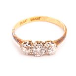 A vintage three stone diamond ring, the old cuts in platinum claws on an 18ct gold band