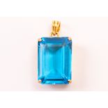 A blue stone pendant, the large rectangular stone in pierced yellow metal mount marked 18k