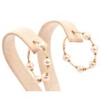 A pair of Middle Eastern yellow metal and pearl earrings, the hoops set with five white pearls,